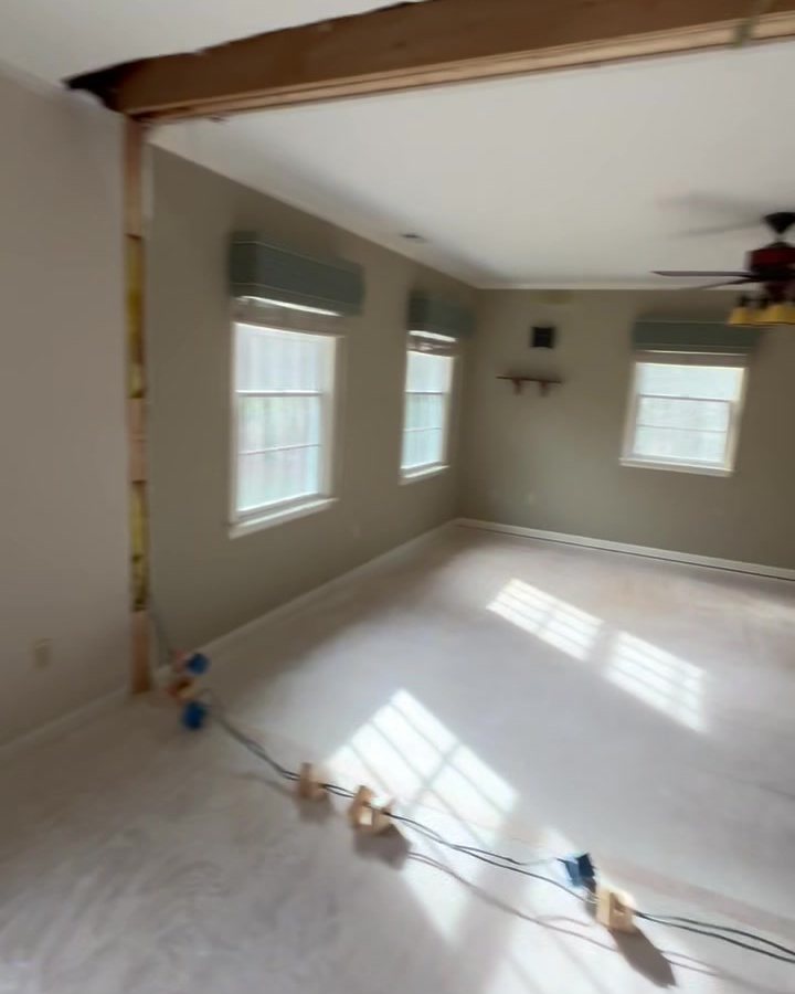 A stripped room with bare subfloor and new electrical rough-in before finishes go on.